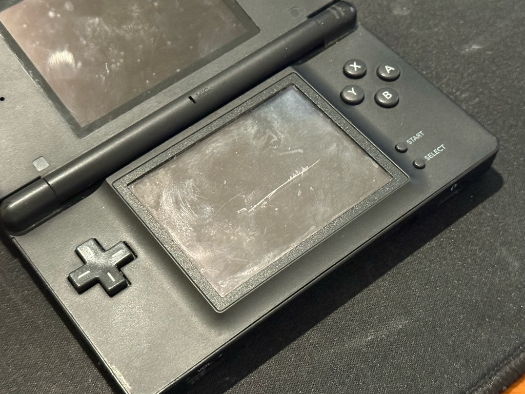 Black DS Lite with a heavily scratched and scuffed bottom touch screen.