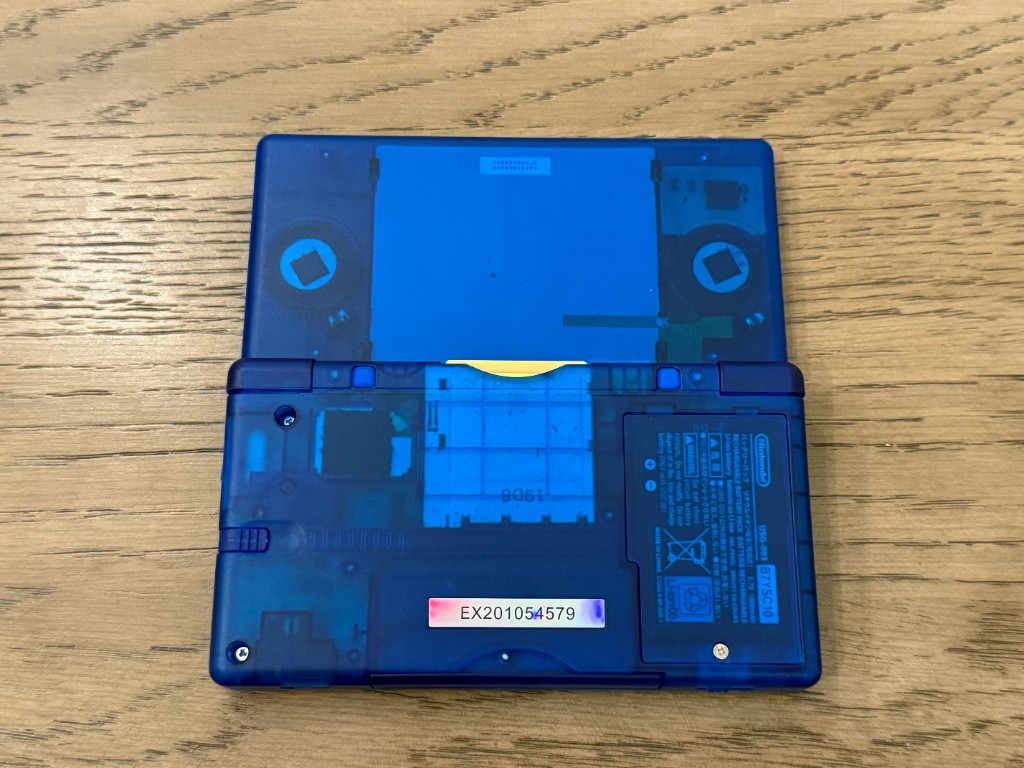 The back of a translucent blue DS Lite, with the shell interior visible.