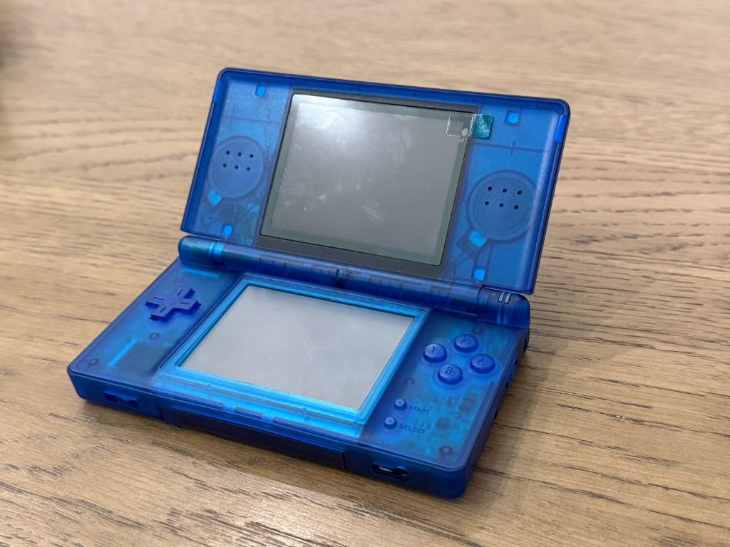 A translucent blue DS Lite opened after a reshell.