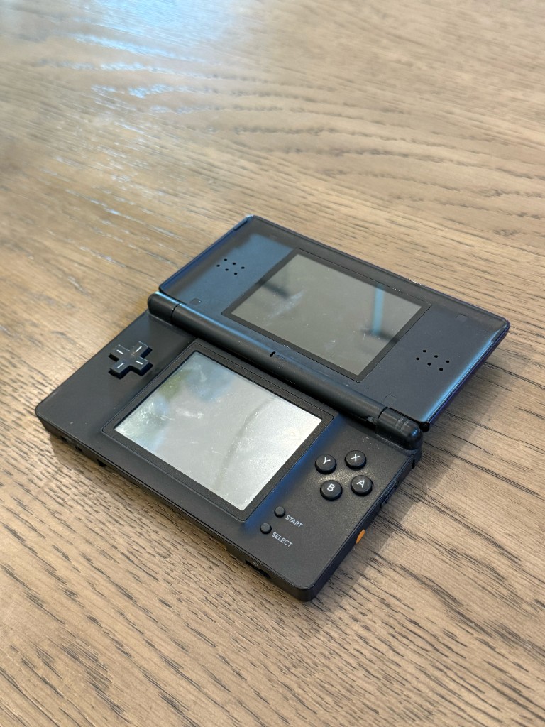 The same DS Lite opened before a reshell, with scratched screens.