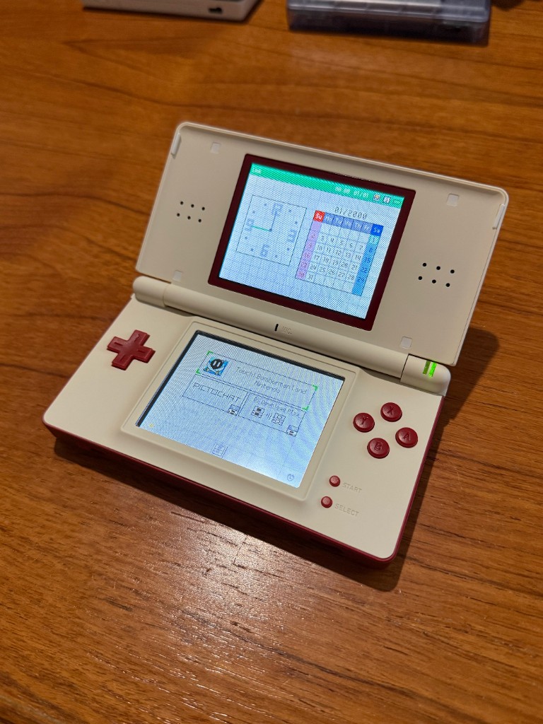 A white and red DS Lite opened and powered on after a reshell.