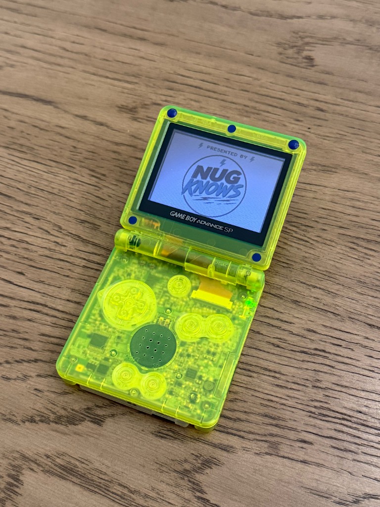 Clear lime-green GBA SP opened and powered on after the shell swap.