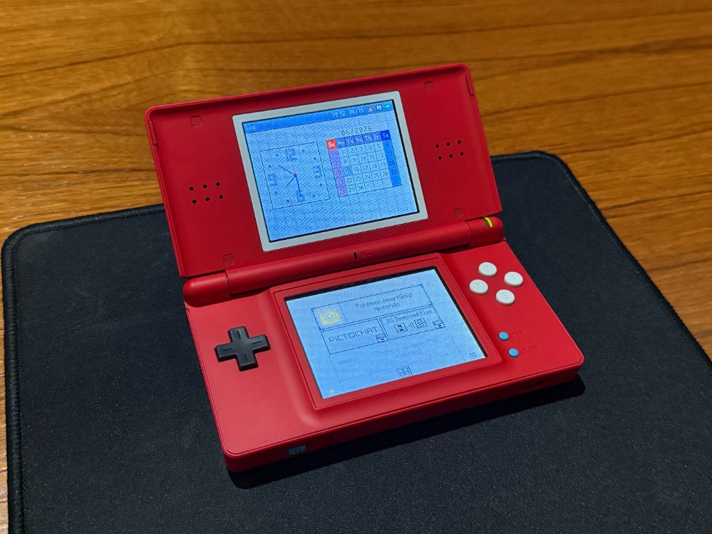 The red Pokedex DS Lite opened and powered on, with both screens working.